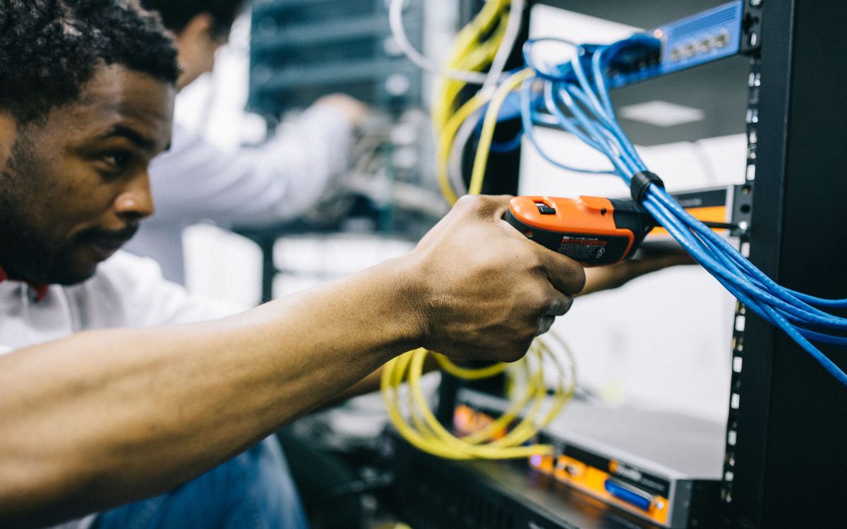 Engineer installing network equipment in a rack on site