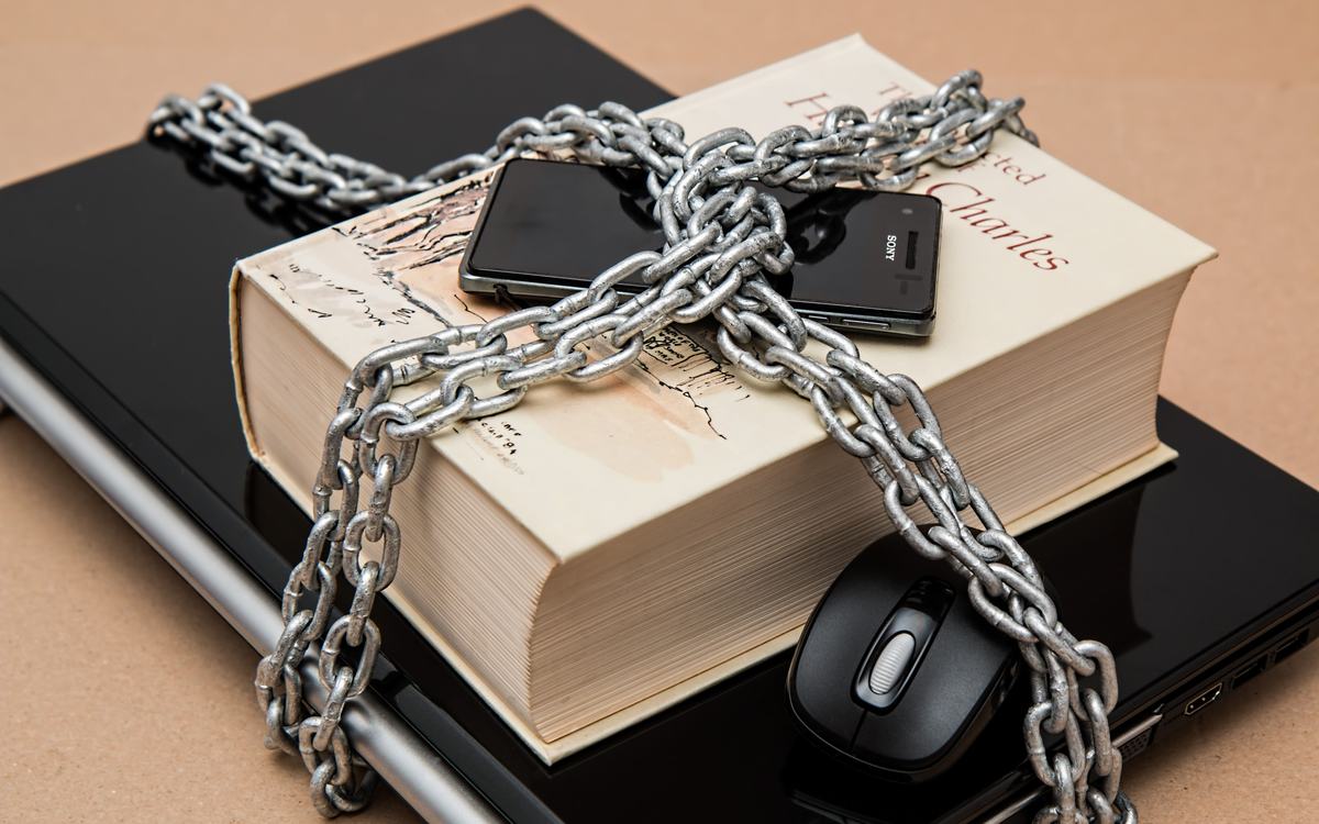 Laptop, phone and book locked together with a chain