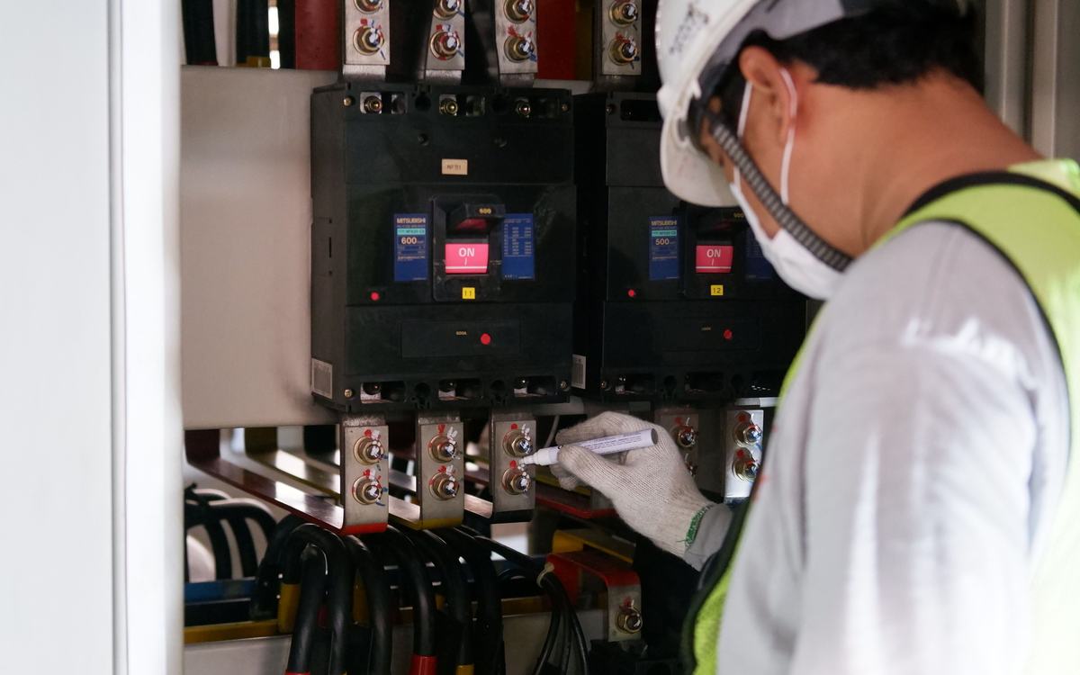 Electrician checking breakers in a distribution board
