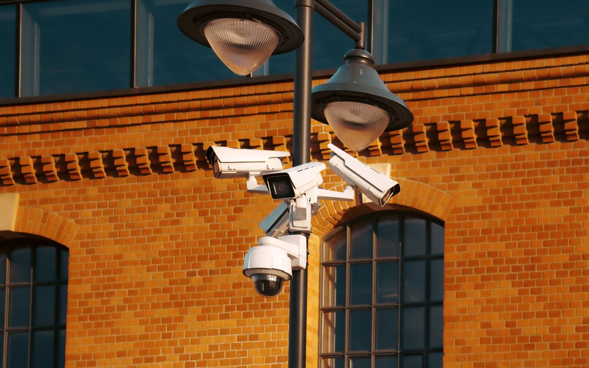 CCTV cameras on a pole outside a brick building